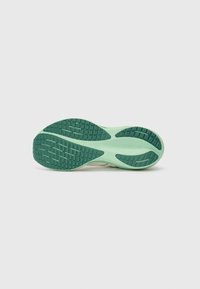 Zapatilla de running ligera con una suela de goma verde menta texturizada, que presenta un patrón de olas y ranuras poco profundas para mejorar la tracción.