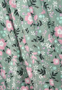 Grüner Blumenstoff mit rosa, weißen und blauen Blumen, schwarzem Laub und kleinen goldenen Akzenten, die ein strukturiertes Muster ergeben.