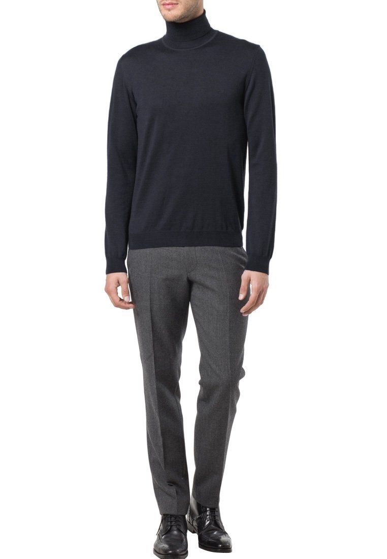 Marinefarbener Rollkragenpullover aus einem leichten Strick, kombiniert mit maßgeschneiderten, dunkelgrauen Hosen. Auffällige Akzente sind das figurbetonte Design und die gerippten Bündchen.
