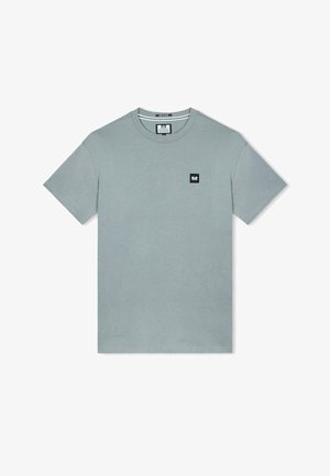 Šviesiai žalias medvilninis marškinėliai su trumpomis rankovėmis. Kairėje krūtinės pusėje yra juodas kvadrato logotipas. Apvalus iškirpimas, paprastas dizainas ir lygi tekstūra.