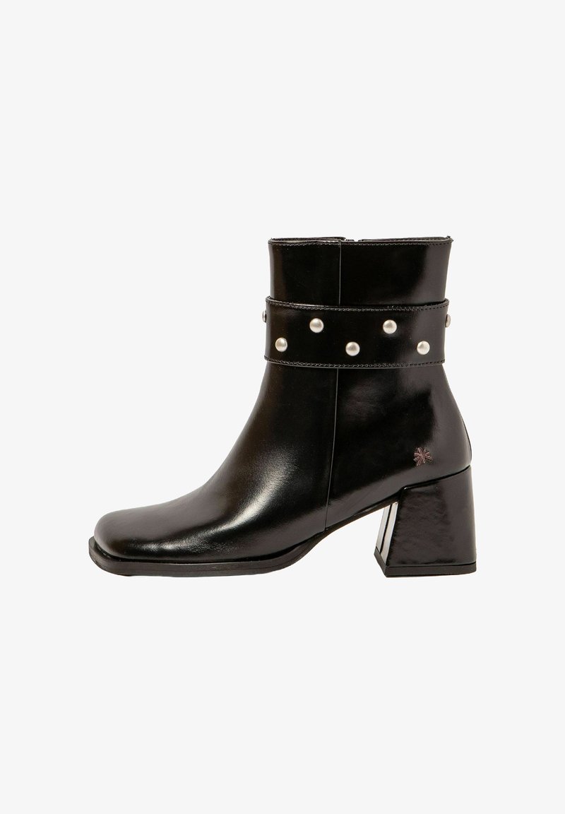 Botín negro hasta el tobillo con punta cuadrada, acabado en cuero brillante, banda ancha con acentos de tachuelas plateadas y tacón cuadrado.