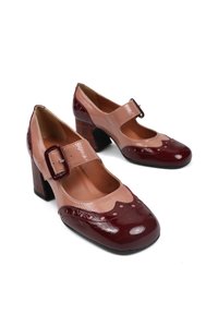Czółenka Mary Jane z błyszczącym bordowym noskiem, różową skórzaną cholewką, falbaniastym brzegiem i prostokątnym zapięciem. Grubszy czarny obcas.