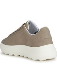 Baskets beiges en matériau lisse, bout rond et semelle blanche épaisse. Présentent des lacets marron et un design minimaliste avec des coutures discrètes.