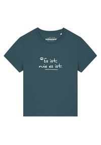 T-shirt col rond teal en coton, avec du texte blanc : "Es ist, wie es ist," sur le devant, ayant une coupe décontractée et des manches courtes.