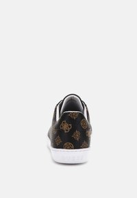 Sneaker nera in faux pelle con superficie texture e motivi geometrici oro, dotata di suola in gomma bianca e branding sul tallone.