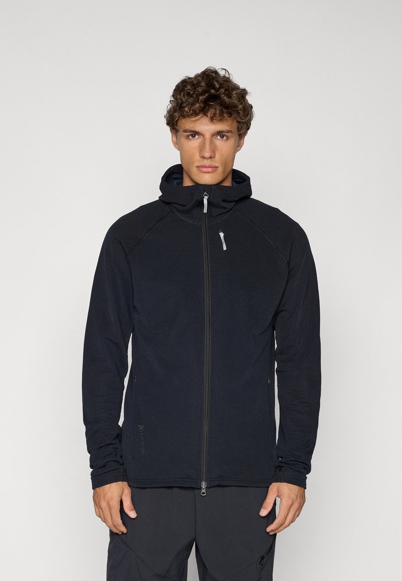 Schwarze Zip-Up-Hoodie aus strukturiertem Stoff, mit einem frontalen Reißverschluss, Kapuze und Daumenlöchern an den Bündchen. Slim-Fit-Design.