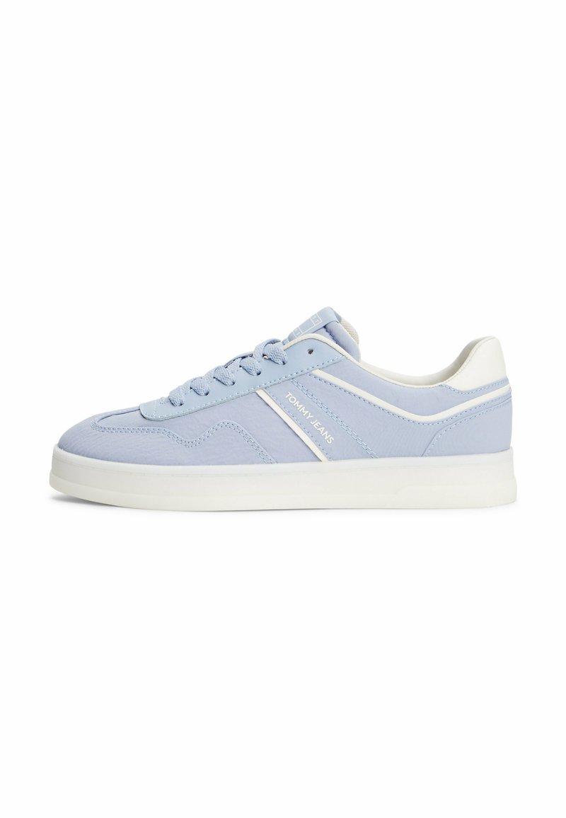 Sneaker azzurro chiaro con accenti bianchi, dotato di suola piatta e lacci, vista laterale che mette in evidenza il logo sul lato esterno.