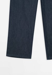 Dunkelblaue Jeans mit geradem Bein, die eine subtile Textur und einen sauberen Saum aufweisen. Keine sichtbaren Beschläge oder Verzierungen.