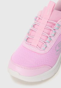 Scarpa da ginnastica rosa chiaro con tomaia in rete testurizzata, lacci elastici con dettagli in turchese e suola in gomma bianca.