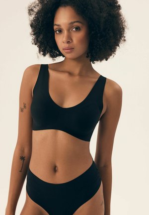 Black seamless bra and high-waisted brief set, featuring wide straps, a smooth texture, and a minimalist design without visible hardware.