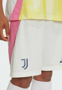 White athletic shorts with a pink side panel, featuring a navy logo on the front, made of smooth synthetic fabric.