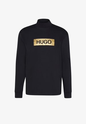 Schwarzes Langarmshirt aus Baumwolle mit einem goldenen metallischen rechteckigen Logo, auf dem in der Mitte "HUGO" in Schwarz gedruckt ist.
