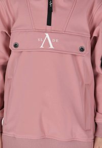 Roze pullover met een kwart rits, voorzien van een grote borstzak, logo-detaillering en geribde manchetten. Gemaakt van glad, rekbaar materiaal.