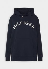 Sweat à capuche bleu marine avec une poche kangourou, capuche à cordon de serrage et logo "HILFIGER" brodé en blanc sur la poitrine. Tissu en mélange de coton.