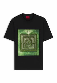 Zwart T-shirt met een centrale groene maze-afbeelding, met het merk "HUGO" boven het design. Korte mouwen en een klassieke ronde hals.