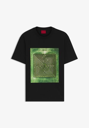 Black T-shirt featuring a central green maze graphic, with the brand "HUGO" above the design. Short sleeves and a classic crew neck.