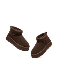 Braune Knöchelstiefel mit einem weichen Innenfutter, Wildlederschaft, abgerundeter Zehenpartie, flacher Gummisohle und einem knöchelhohen Design.