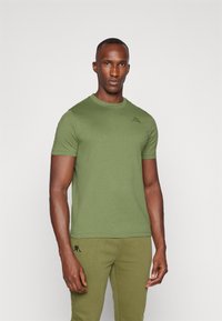 Ελαιόλαδο πράσινο εφαρμοστό μπλουζάκι φτιαγμένο από βαμβάκι, με στρογγυλή λαιμόκοψη και κοντά μανίκια. Περιλαμβάνει ένα μικρό κεντητό λογότυπο στο στήθος.