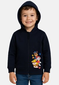 Felpa con zip di colore blu navy realizzata in materiale morbido, caratterizzata da vivaci cartoni animati di cani sul davanti. Ha una tasca a marsupio e un cappuccio accogliente.