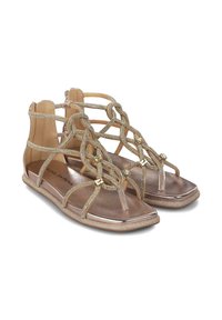 Sandalias de bronce metálico con correas entrecruzadas y herrajes decorativos. Suela plana y diseño abierto; textura suave con un acabado brillante.