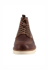 Stivaletti in pelle marrone con punta tonda, lacci beige, cuciture in contrasto e parte superiore texturizzata. Suola in gomma con leggera elevazione.