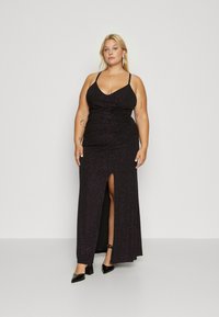 Black, sleeveless gown with a deep V-neck, ruched detail, and a thigh-high slit. Sparkling texture enhances its elegant design.