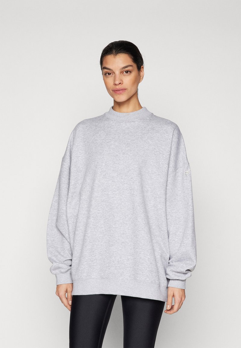 Sudadera gris de gran tamaño con cuello alto, puños acanalados y un corte relajado, hecha de una suave tela de mezcla de algodón texturizada.