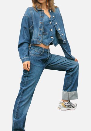 Veste en denim bleu raccourcie avec des boutons argentés et jean taille haute assorti. Caractéristiques : jambes larges et ourlet effiloché au niveau des poignets.