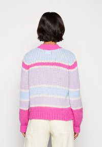 Stickad tröja med pastellrand i rosa, lavendel och blått. Kraftig textur med ribbat krage och ärmslut.