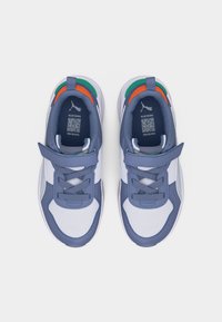 Ζευγάρι μπλε και λευκά αθλητικά παπούτσια Puma με πορτοκαλί και πράσινες λεπτομέρειες, δεμένα με κορδόνια και λουριά Velcro, απεικονιζόμενα από πάνω σε λευκό φόντο.