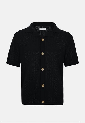 Cardigan noir à manches courtes en maille avec col, motif en maille ajourée et six boutons beige à l'avant.