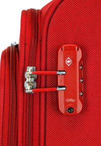Roter Koffer mit einer strukturierten Stoffoberfläche, Doppelreißverschlüssen mit metallischen und roten Verriegelungsmechanismen sowie einem TSA-zugelassenen Zahlenschloss.