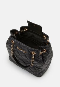 Musta, poimutettu nahkalaukku kullanvärisillä yksityiskohdilla, jossa on ketju- ja nahkaelementtejä, tilava sisäosa, jossa on läppäkiinnitys ja brändilogo.