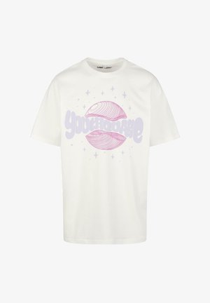 Fehér pamut póló, amelyen világos lila és rózsaszín grafikai dizájn látható a "Youthquake" felirattal és absztrakt formákkal, csillagokkal a háttérben.