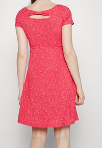 Rotes Kleid aus gemustertem Stoff, mit kurzen Ärmeln, einem Schlüsselloch-Rücken mit einer Schleifendetails und einem ausgestellten Rock.