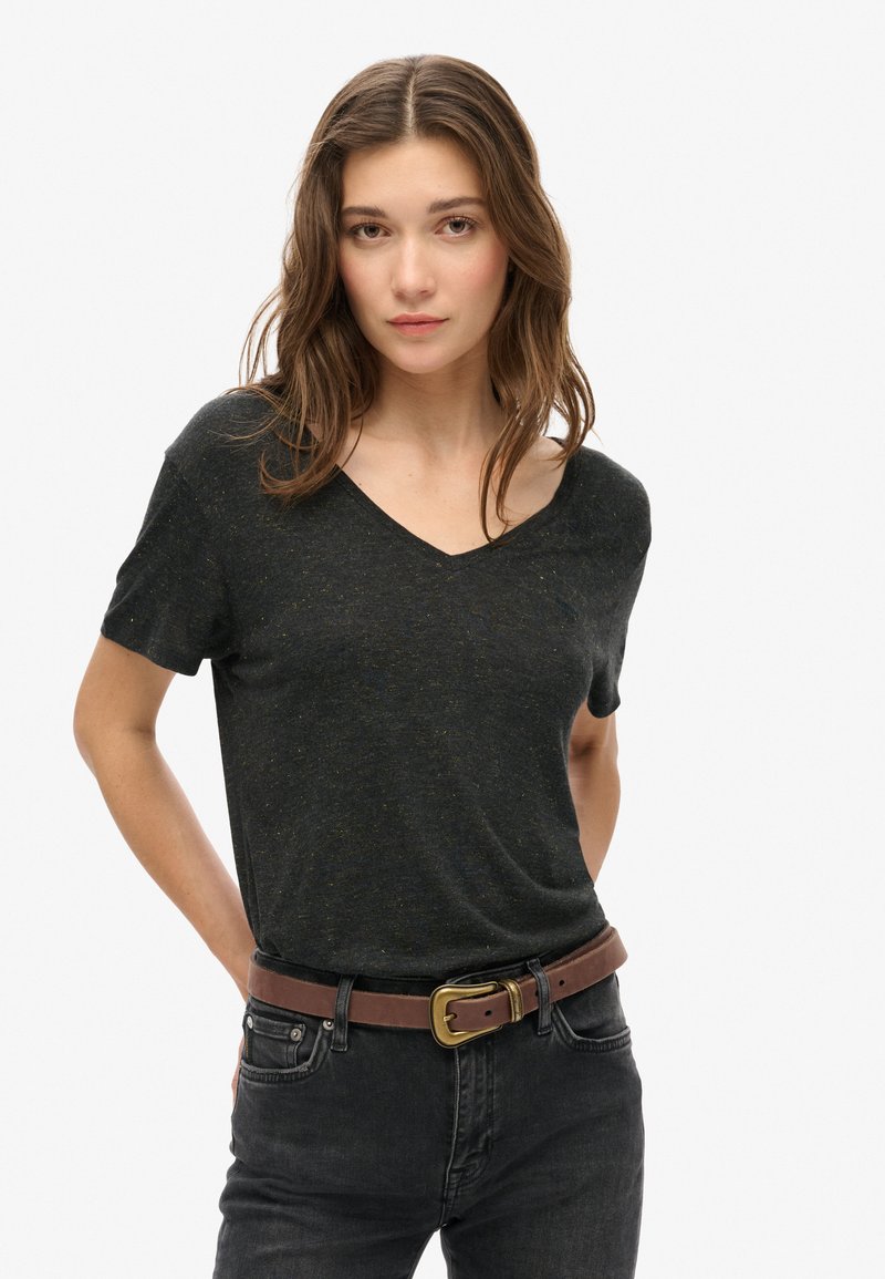 Mørkegrå V-hals t-shirt lavet af et tekstureret, let stof, parret med mørke jeans og et brunt bælte med en guldbuckle.