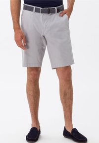 Pantaloni corti in cotone grigi con parte anteriore piatta, tasche laterali e una cintura a fantasia blu navy. Indossati con mocassini in camoscio blu navy.