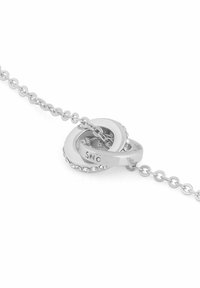 Silverfärgad armband med sammanlänkade cirkulära länkar, där en av länkarna är prydd med små klara stenar, fäst vid en subtil kedja.