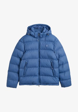 Giacca a vento blu con cappuccio, design trapuntato, due tasche laterali con zip e un piccolo dettaglio del logo sul petto. Materiale morbido e isolato.