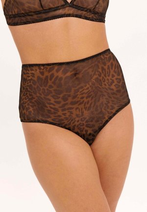 Vrouw draagt transparante, hooggetailleerde bruine ondergoed met luipaardprint en zwarte biezen tegen een witte achtergrond.