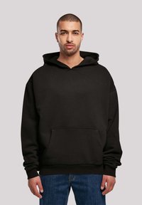 Black hooded sweatshirt made of soft fabric, featuring a kangaroo pocket, ribbed cuffs, and hem, with a relaxed silhouette.