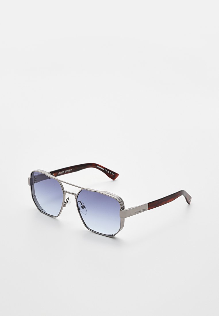 Silverfärgade solglasögon med metallram, gradientblå linser och skalm med sköldpaddsmönster som vilar på en vit yta.