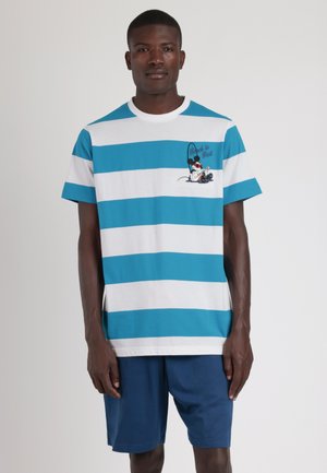 Camiseta a rayas en algodón de color azul claro y blanco, con un gráfico de un personaje con una caña de pescar y el texto "La bicicleta es lo mejor". Combinada con pantalones cortos color marino.