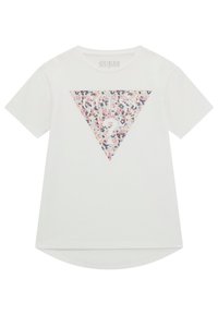 T-shirt blanc en coton biologique avec un motif floral triangulaire en rose, bleu et blanc, avec le texte "GUESS?" au centre.