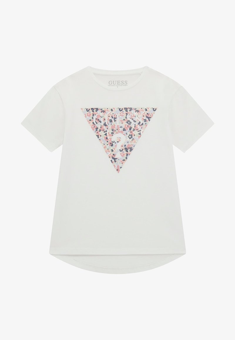T-shirt blanc en coton biologique avec un motif floral triangulaire en rose, bleu et blanc, avec le texte "GUESS?" au centre.