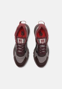 Bordeaux- og grå sneakers med teksturert overdel, polstret tunge og lisser. Logo-tag synlig på tungen; gummisåle med solid grep.