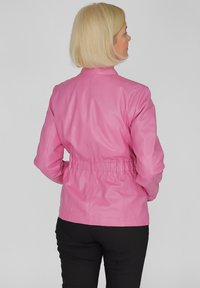 Rosa Lederjacke mit tailliertem Schnitt, elastischem Bund und langen Ärmeln. Glatte Textur, minimalistischer Stil und keine sichtbaren Beschläge.