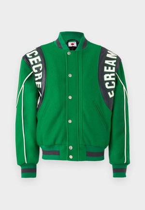 Zielona kurtka varsity z zapięciem na guziki z przodu, czarną skórzaną wstawką na ramionach oraz białymi lamówkami wzdłuż rękawów.