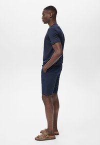 Marinblå bomull t-shirt och shorts-set, med korta ärmar och avslappnad passform. Sandaler med justerbara remmar fulländar looken.