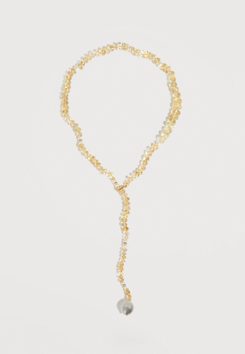 Collier perlé jaune avec un design en boucle et un brin suspendu se terminant par une seule perle ronde translucide.